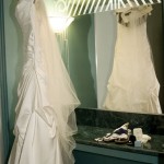The wedding dress and veil hanging in the dressing area with the shoes, jewelry, and other accessories.