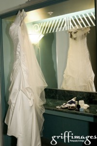 The wedding dress and veil hanging in the dressing area with the shoes, jewelry, and other accessories.