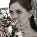 Beautiful bride peeking through her bridal bouquet.