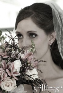 Beautiful bride peeking through her bridal bouquet.