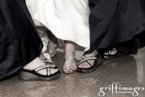 Bride and bridesmaids showing off their blinged out shoes.
