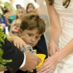 Bride's son pouring sand into the vase during the sand ceremony of the wedding.