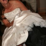 The bride laughing during the groom's "no-hands" retrieval of the garter.