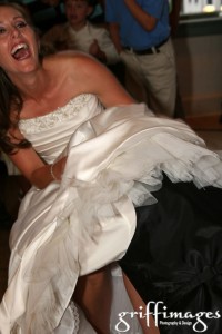 The bride laughing during the groom's "no-hands" retrieval of the garter.