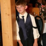 One of the junior groomsmen watching the happy couple during their first dance.