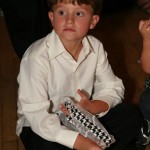 The bride's son caught the garter, and he's holding on to it during the happy couple's first dance.