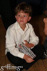 The bride's son caught the garter, and he's holding on to it during the happy couple's first dance.